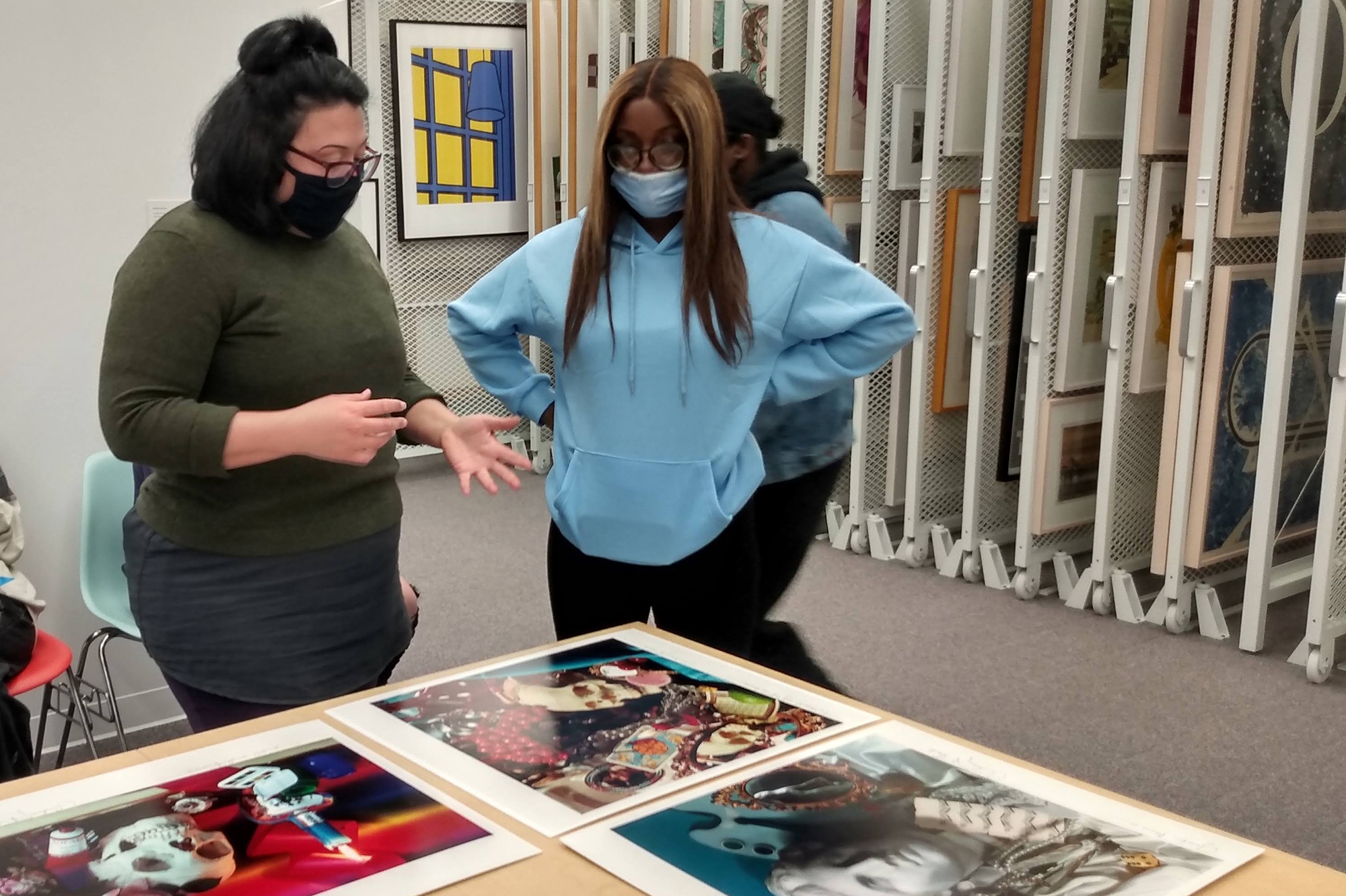 Students looking at photographs by Audrey Flack.